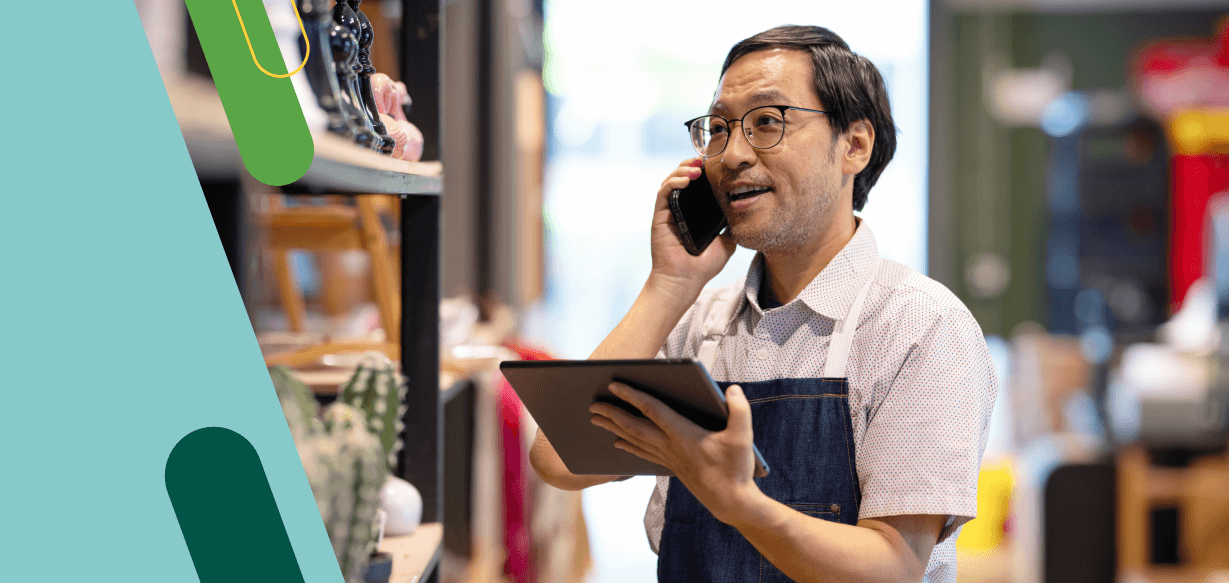 Empleado en el trabajo en una tienda minorista hablando por un teléfono celular