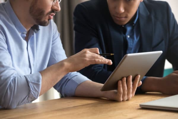 Two men collaborating on tablet computer