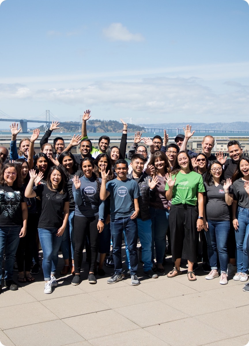 A Group of People Standing Outside Looking at the Camera and Waving