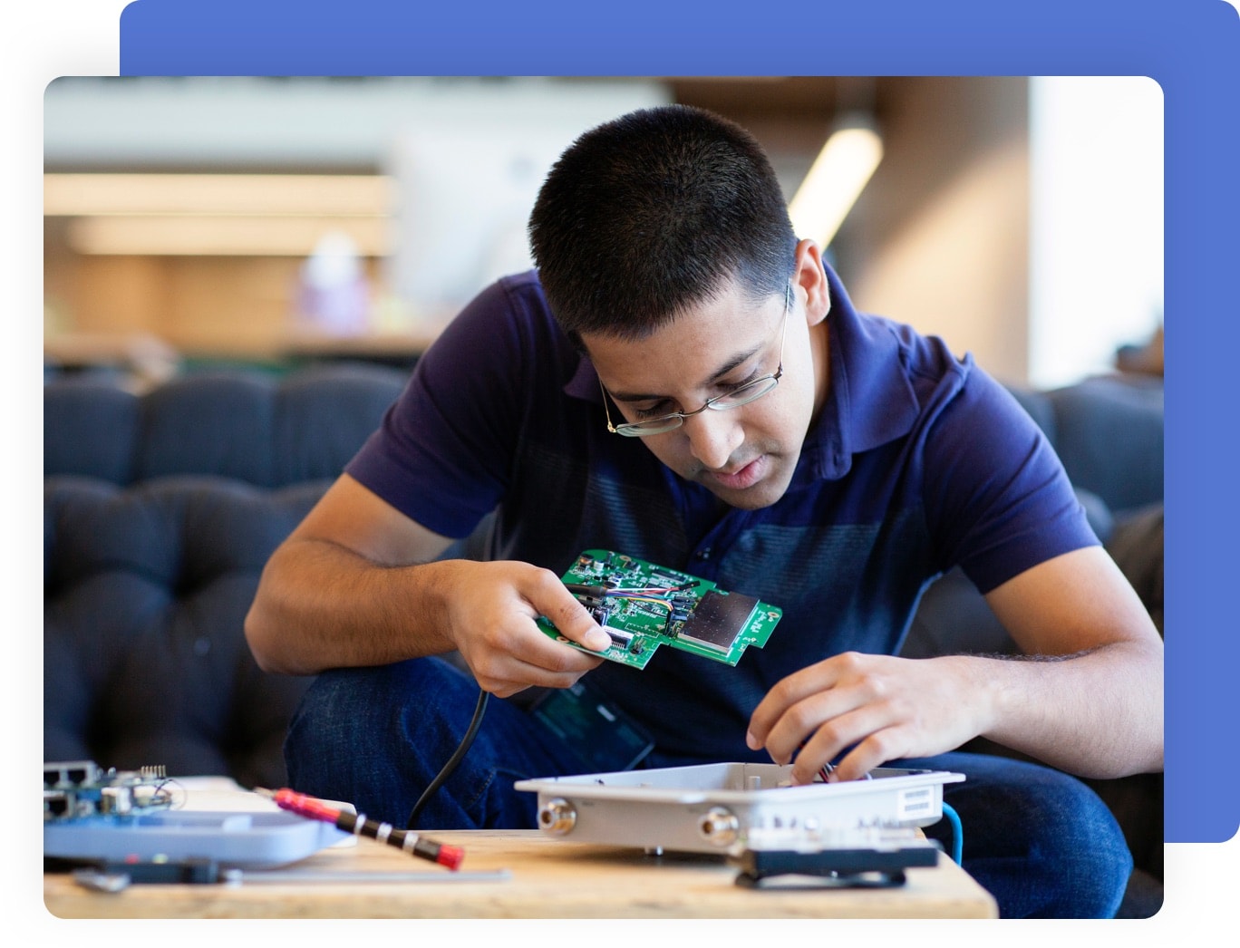 A Man Sitting Down Working with an Electronic Device