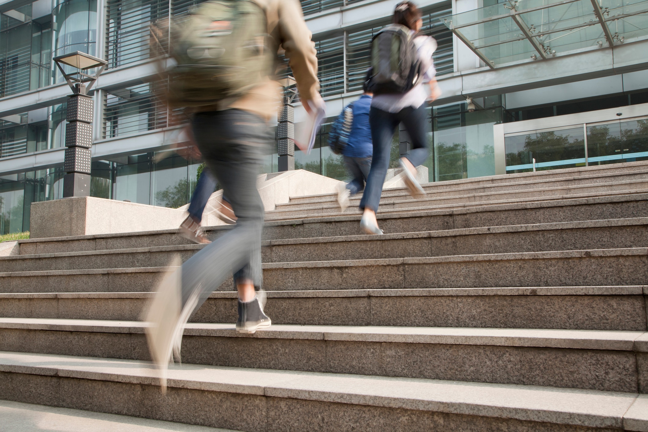 Four people outside running up a flight of stairs